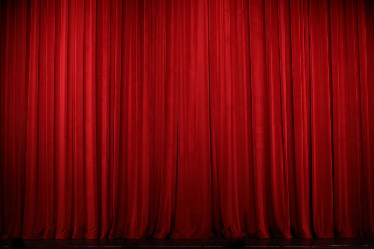 Red fabric curtain hanging across a theatre stage