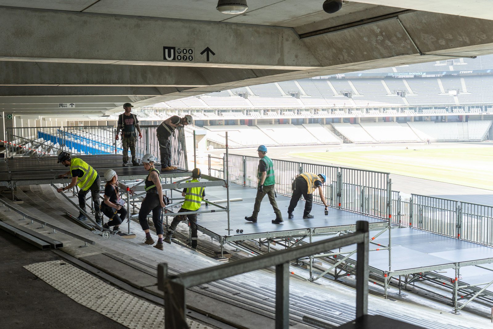 Crew assembling temporary stage decks at a stadium venue